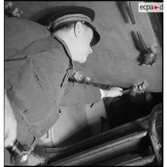 Alerte à bord du cuirassé Dunkerque : l'ingénieur en chef verrouille un panneau d'accès.