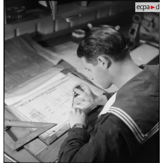 Etude d'une pièce du compartiment des machines par un marin du cuirassé Dunkerque.