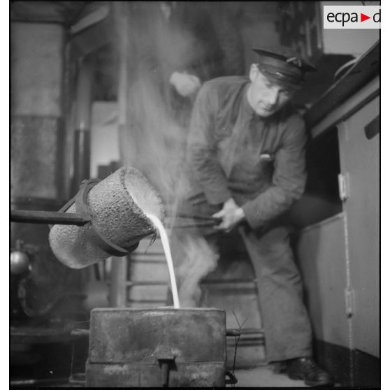 Coulée de métal en fusion dans un moule dans le compartiment des machines du cuirassé Dunkerque.