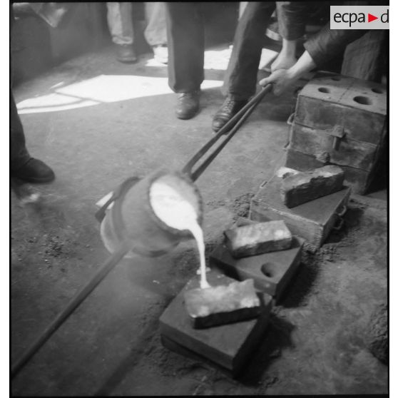Coulée de métal en fusion dans un moule dans le compartiment des machines du cuirassé Dunkerque.