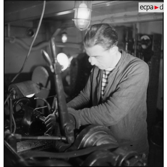 Façonnage d'une pièce et finition sur un tour à bord du cuirassé Dunkerque.