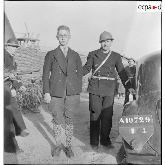 Un prisonnier civil surveillé par un officier marinier à Dunkerque.