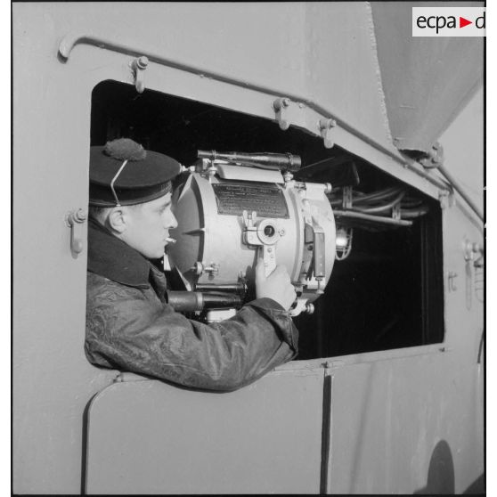 Portrait d'un timonier à bord du cuirassé Dunkerque manoeuvrant un projecteur Scott.