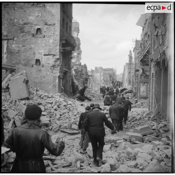 Louis Jacquinot, ministre de la Marine, et les autorités qui l'accompagnent lors de sa visite arpentent Brest en ruines.