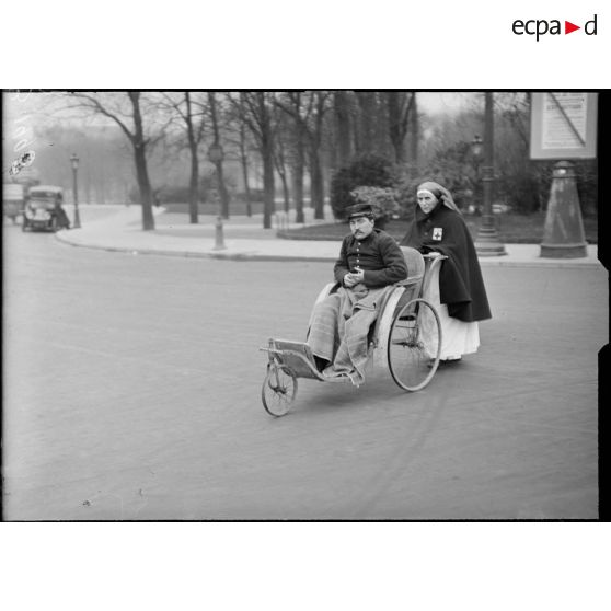 Paris Champs Elysées, infirmière promenant un grand blessé. [légende d’origine]