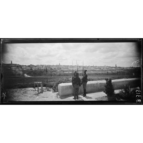 Meknès, la relève des sentinelles au QG, au fond panorama de la ville. [légende d’origine]