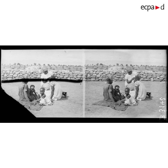 Meknès, le camp des femmes sénégalaises, famille sénégalaise, les soins de la chevelure. [légende d’origine]