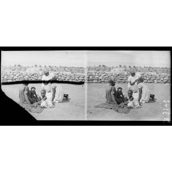 Meknès, le camp des femmes sénégalaises, famille sénégalaise, les soins de la chevelure. [légende d’origine]