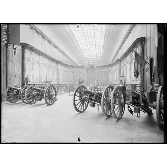 Petit Palais, exposition des œuvres d’arts mutilés, les boiseries de la catéhdrale de Verdun, époque Louis XV, au 1er plan, les canons donnés à Verdun en souvenir de la belle conduite des habitants pendant le siège de 1870. [légende d’origine]