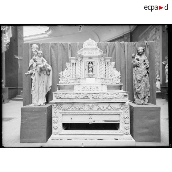 Petit Palais, exposition des œuvres d’arts mutilées, maître autel de l’église de Reuves (Marne), à gauche vierge à l’enfant église de Neuville-au-Pont, à droite vierge à l’enfant. [légende d’origine]