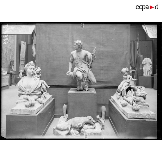 Petit Palais, exposition des œuvres d’arts mutilées, à gauche et à droite sphinx terre cuite, au centre, Acteon, terre cuite attribué à Couston provenant du parc du château à Vic/Aisne. [légende d’origine]
