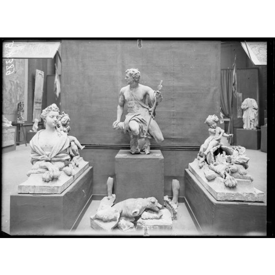 Petit Palais, exposition des œuvres d’arts mutilées, à gauche et à droite sphinx terre cuite, au centre, Acteon, terre cuite attribué à Couston provenant du parc du château à Vic/Aisne. [légende d’origine]