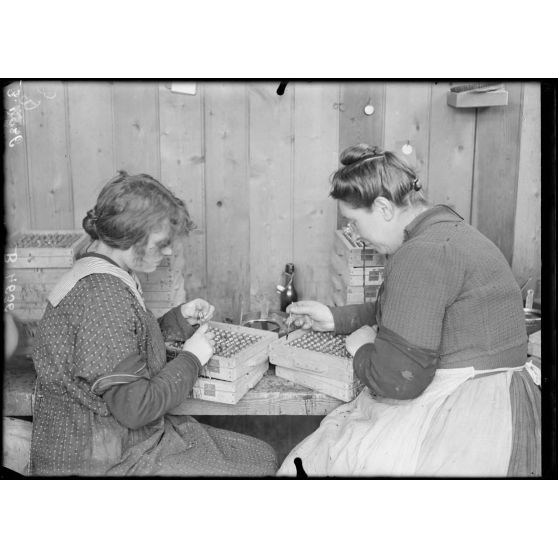 St Ouen, usine Ruggieri, artificier. Chargement et amorçage des fusées d’obus VB. Fermeture à la cire de l’évent supérieur. [légende d’origine]