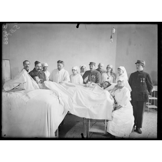 Paris, hôpital du Grand Palais, opération de la greffe des os, par le Dr Laurent. Les deux opérés, les infirmières et le docteur Laurent. [légende d’origine]