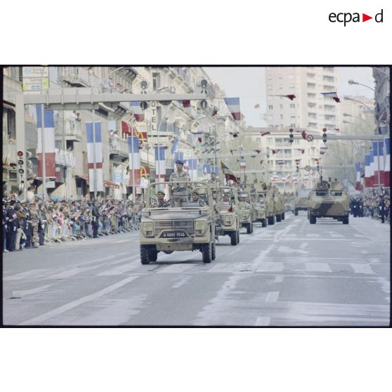 Derrière le lieutenant-colonel Yves Derville, chef de corps, et son drapeau, le 2e REI (régiment étranger d'infanterie) défile à bord de P4 et de VAB à Toulon.