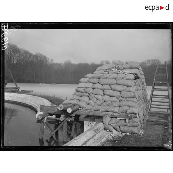 Versailles. Protection des oeuvres d'art dans les jardins du Palais de versailles. Groupe de la Garonne sous les sacs à terre. [légende d'origine]