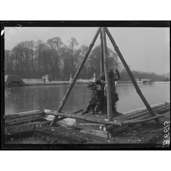 Versailles. Protection des oeuvres d'art dans les jardins du Palais de versailles. Groupe "Jeu d'enfants". [légende d'origine]