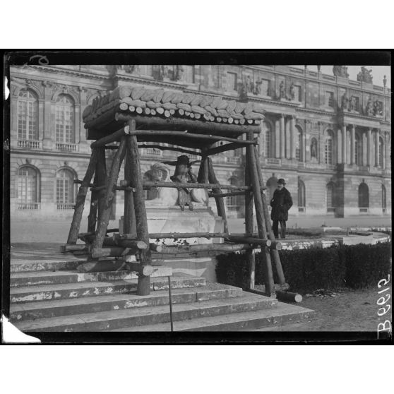 Versailles. Protection des oeuvres d'art dans les jardins du Palais de versailles. Groupe "L'enfant au Sphynx". [légende d'origine]