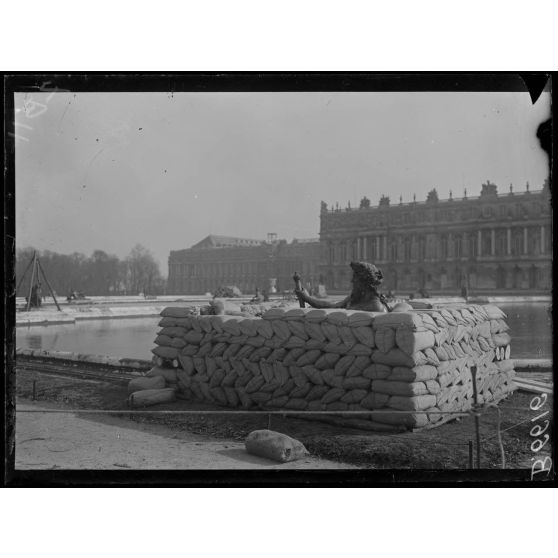 Versailles. Protection des oeuvres d'art dans les jardins du Palais de versailles. Groupe du Rhône en voie de recouvrement de sacs à terre. [légende d'origine]