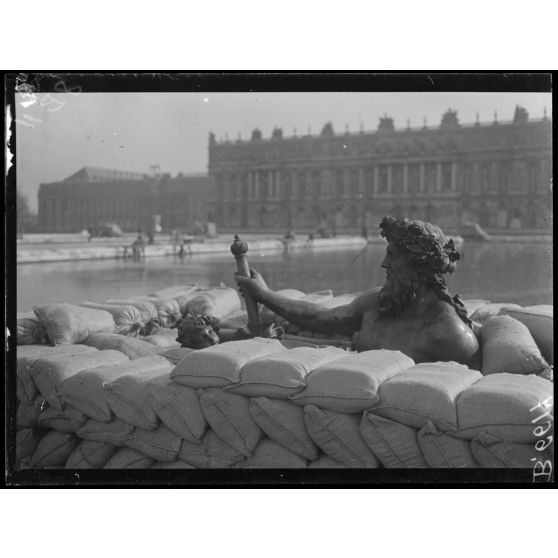 Versailles. Protection des oeuvres d'art dans les jardins du Palais de versailles. Groupe du Rhône en voie de recouvrement de sacs à terre. [légende d'origine]