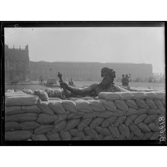Versailles. Protection des oeuvres d'art dans les jardins du Palais de versailles. Groupe du Rhône en voie de recouvrement de sacs à terre. [légende d'origine]