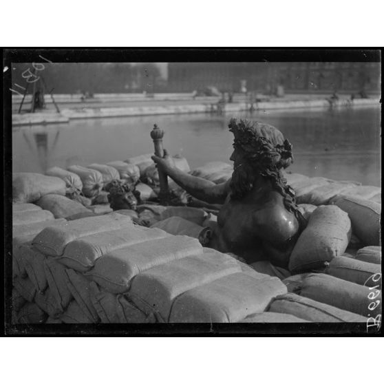 Versailles. Protection des oeuvres d'art dans les jardins du Palais de versailles. Groupe du Rhône en voie de recouvrement de sacs à terre. [légende d'origine]