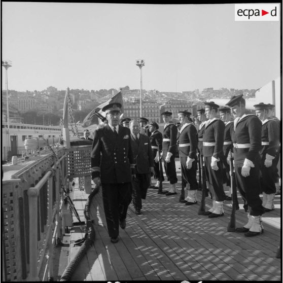 Accompagné du commandant du Georges Leygues, monsieur Robert Lacoste passe en revue la garde d'honneur.