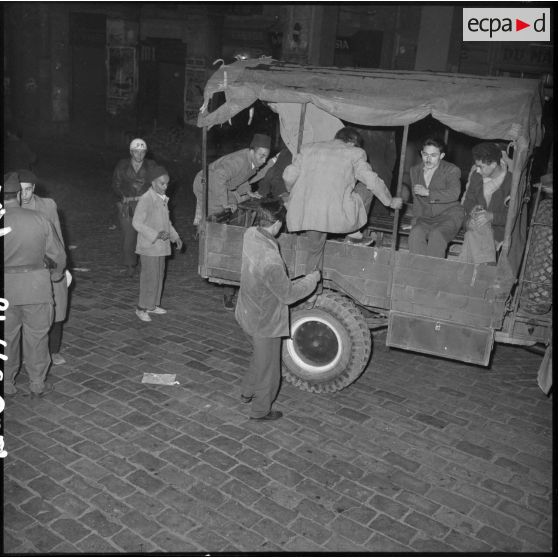 Les ouvriers sont embarqués dans des camions de l'armée.