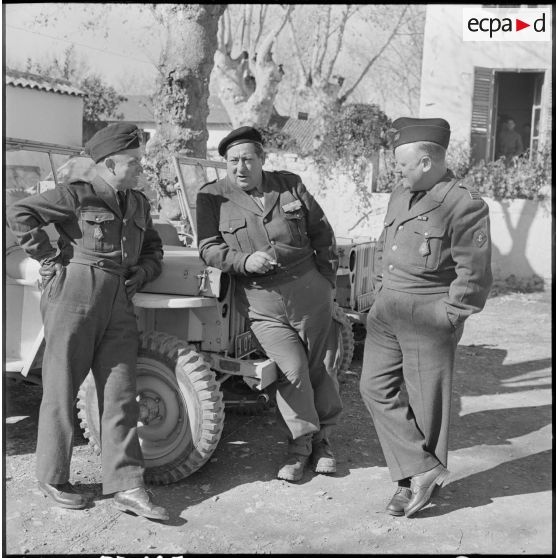 Portrait en pied de deux officiers du RCCC et de l'opérateur de prise de vue Gérard Py.