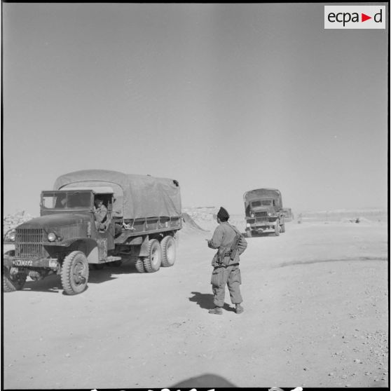 Colonne de GMC 6x6 progressant sur une piste.