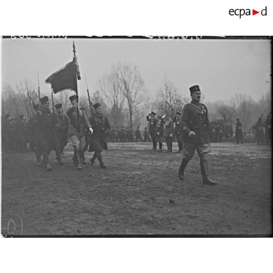 Le drapeau du 8e régiment de zouaves et sa garde défilent devant les autorités civiles et militaires.