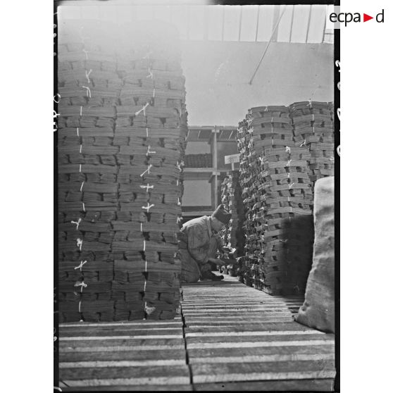 Des ouvriers s'activent dans l'entrepôt de feuilles de cuir de l'usine de chaussures.