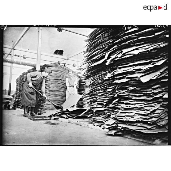 Des ouvriers s'activent dans l'entrepôt de feuilles de cuir de l'usine de chaussures.