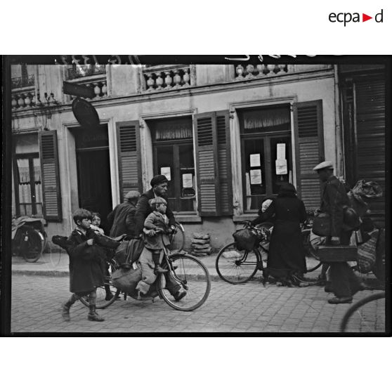 Dans un village des réfugiés circulent, des vélos servent au transport des bagages et des enfants.