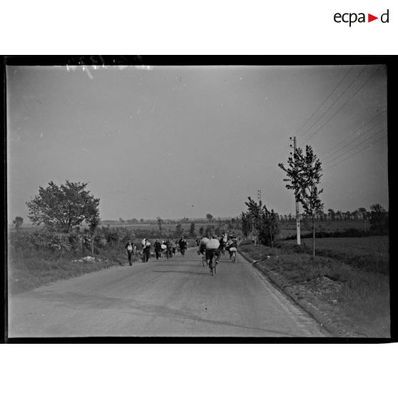 Plan général de réfugiés qui circulent à vélo sur une route.