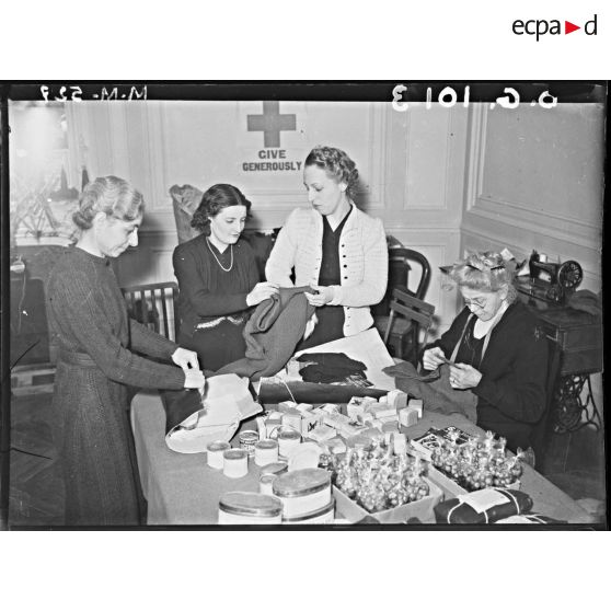 Des femmes confectionnent des colis destinés aux soldats.