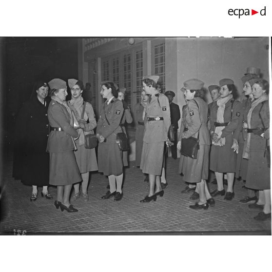 Madame Paul Reynaud discute avec des conductrices de la section sanitaire automobile dans une salle d'attente.