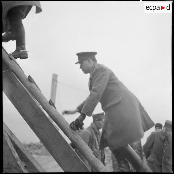 Plan moyen d'une personnalité britannique qui monte sur une échelle.