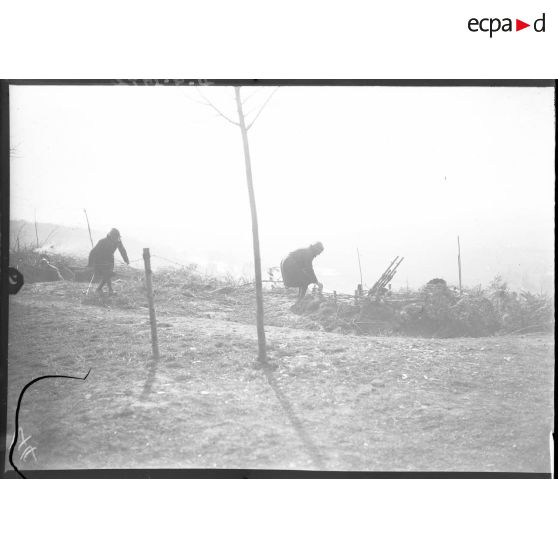 Deux soldats rejoignent un emplacement de mitrailleuses Hotchkiss modèle 1914 jumelées.
