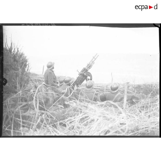 Des soldats servent des mitrailleuses Hotchkiss modèle 1914 jumelées sur affût double de marine.