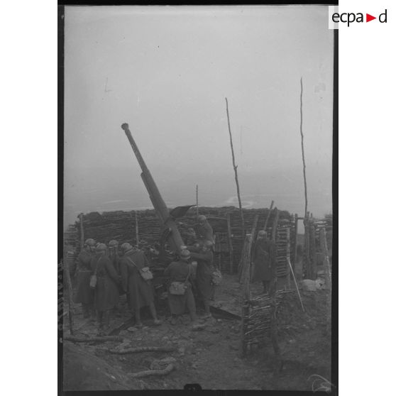 Plan général d'une pièce de 75 mm CA modèle 1930, des artilleurs du 402e RAAA s'affairent autour.