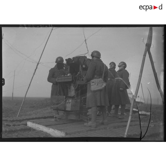 Des artilleurs du 402e RAAA servent un appareil de détection et de conduite de tir d'une batterie de 75 mm CA.