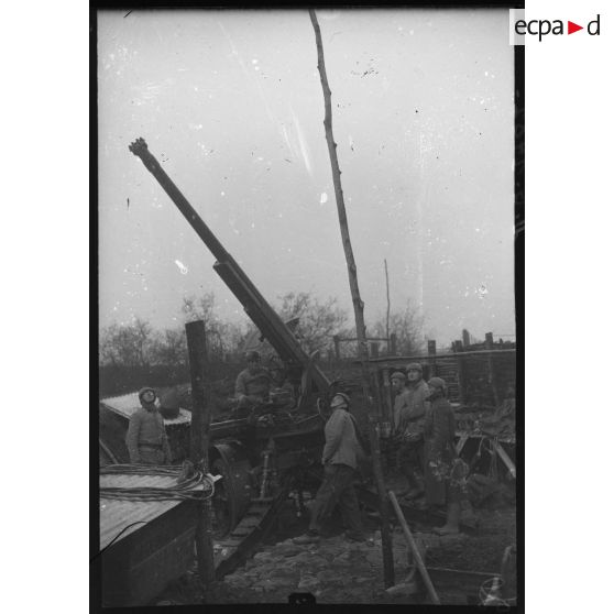 Des artilleurs du 402e RAAA (régiment d'artillerie de défense contre-avions ou dénommé également régiment d'artillerie antiaérienne, composante de la 32e BDCA) approvisionnent une pièce de 75 mm CA modèle 1930.