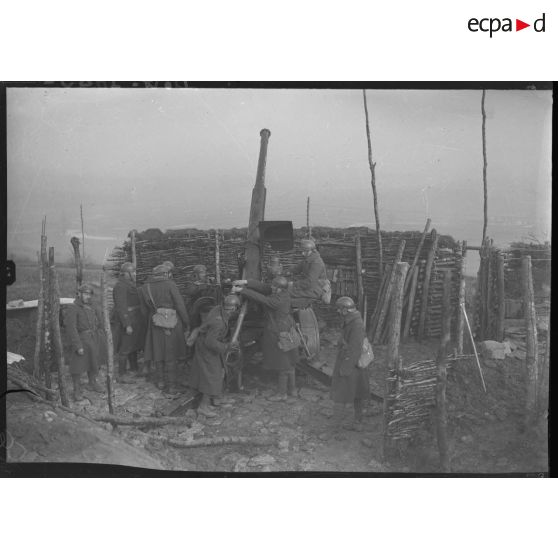 Des artilleurs du 402e RAAA (régiment d'artillerie de défense contre-avions ou dénommé également régiment d'artillerie antiaérienne, composante de la 32e BDCA) approvisionnent une pièce de 75 mm CA modèle 1930.