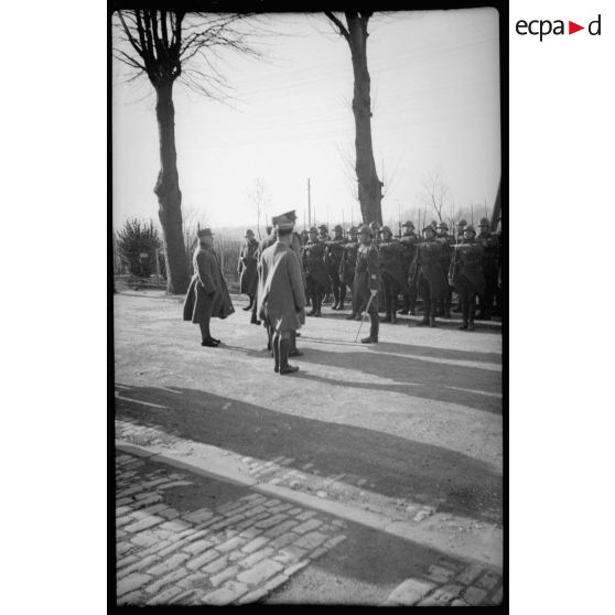 Un piquet d'honneur présente les armes à des officiers généraux de l'armée française et britannique.