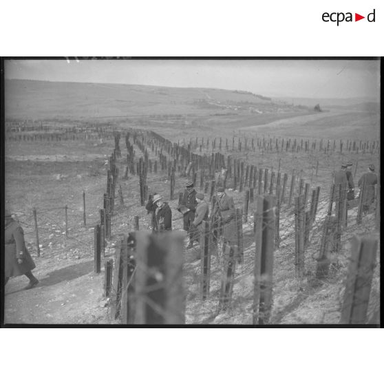 Visite de diverses personnalités sur la ligne Maginot, des visiteurs marchent à travers un champ d'obstacles.