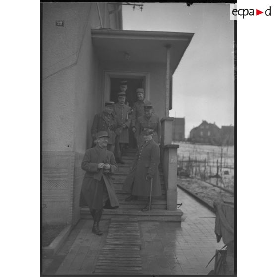 Photographie de groupe d'officiers français et du général d'armée Réquin sur le perron d'une maison.