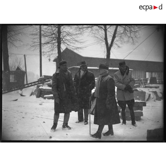Photographie de groupe du général d'armée Réquin entouré de deux militaires et d'un civil.