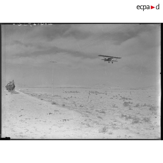 Un peloton de méharistes de la 1re CLD (compagnie légère du désert) est survolé par un Potez 25TOE de l'EO 595.