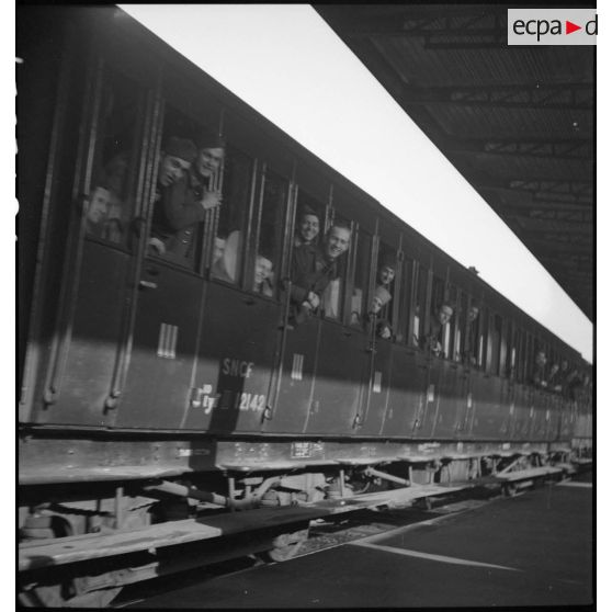 Le départ d'un train de permissionnaires, les soldats sont aux fenêtres des wagons.